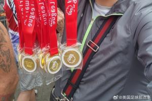 ?球迷在阿森纳冠军巡游卖奖牌，撕开贴纸写着：利物浦是冠军！